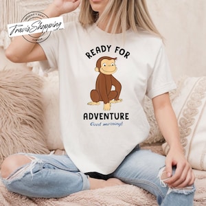 May include: White t-shirt with a cartoon monkey and the text "Ready for Adventure Good morning!"