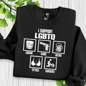 May include: Black sweatshirt with the text "I SUPPORT LGBTQ" and illustrations of liquor, guns, beers, breasts, and sexual activity. The text and illustrations are in white.