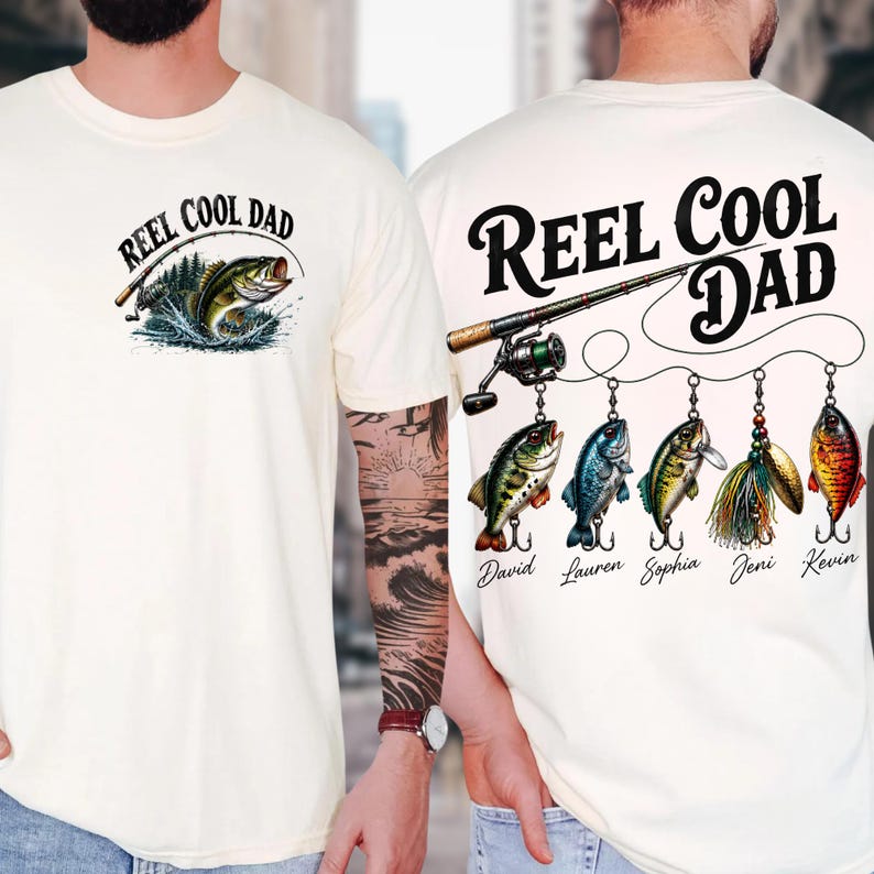 two white t-shirts with fishing-themed designs. The t-shirt on the left has a fishing rod and a fish, while the t-shirt on the right has a fishing rod and a fish, along with the text "Reel Cool Dad" and the names "David", "Lauren", "Sophia", and "Jeni" written below the fish.