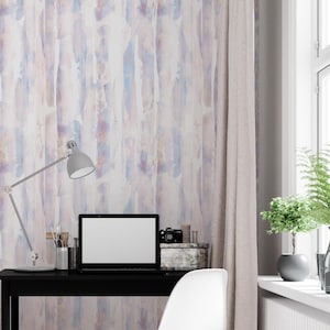 Könnte beinhalten: Ein Vorhang im Aquarellstil mit vertikalen Pinselstrichen in Blau-, Lila- und Beigetönen. Der Vorhang hängt in der Nähe eines Fensters mit weißem Rahmen. Ein schwarzer Schreibtisch mit Laptop, Lampe und Bürobedarf.