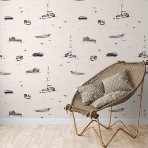 May include: Wallpaper featuring a repeating pattern of black and white boats on a light beige background. The boats vary in size and style, including sailboats and motorboats. A woven chair with pillows is in the foreground.