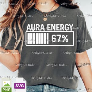 May include: Dark grey t-shirt featuring the text "AURA ENERGY" and a white battery graphic displaying 67% charge. The tee is a relaxed fit, ideal for casual outfits.