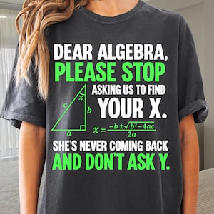 May include: A charcoal gray short-sleeve t-shirt featuring white and bright green text that reads: DEAR ALGEBRA, PLEASE STOP ASKING US TO FIND YOUR X. SHE'S NEVER COMING BACK AND DON'T ASK Y. A green right triangle diagram and quadratic formula are included.