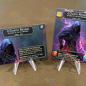 Puede incluir: Dos cartas coleccionables con Darth Revan, un personaje del universo Star Wars. Las cartas se muestran en soportes de plástico transparente. Las cartas tienen una combinación de colores oscuros con tonos morados y negros, e incluyen texto.