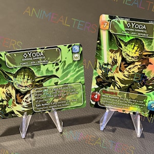 May include: Two collectible Star Wars trading cards featuring Yoda, a Jedi Master. The cards are green and gold with holographic accents. The text on the cards reads "Yoda, Sensing Darkness, Force, Jedi, Republic".