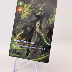 Puede incluir: Una tarjeta coleccionable con una ilustración de un personaje vestido de oscuro y una figura de dragón en el fondo. La tarjeta dice "MASTER YI Wuju Bladesman" con texto adicional. La tarjeta se muestra en un soporte de plástico transparente.