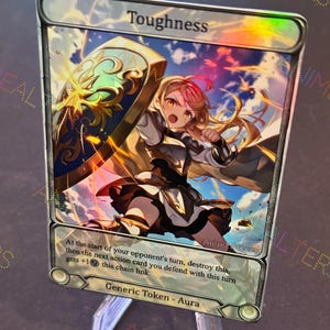 May include: A holographic trading card with the word "Toughness" at the top. The card features an anime-style illustration of a warrior with a shield. The card is displayed on a clear acrylic stand.