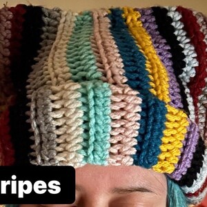 May include: A colorful crocheted hat with stripes of red, white, blue, yellow, green, and purple.