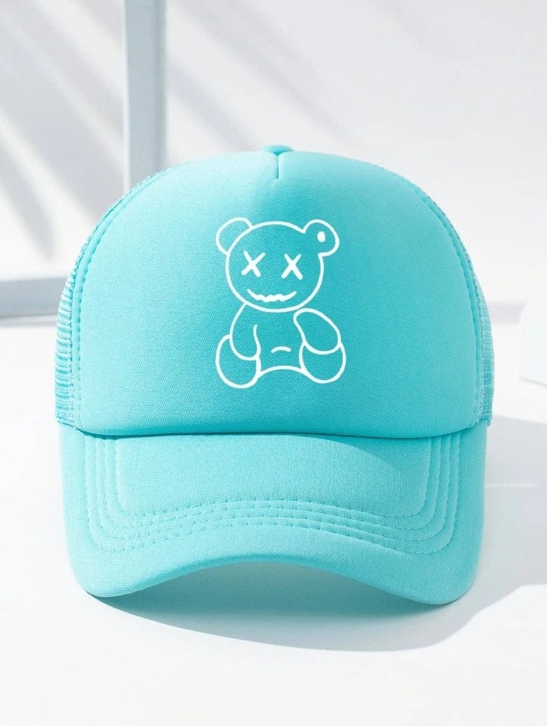 May include: A light blue trucker hat with a white outline of a bear with X's for eyes.