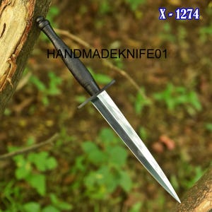 May include: A dagger with a black handle and a silver blade. The handle has a textured grip. The text "HANDMADEKNIFE01" is printed on the handle. The text "X - 1274" is in the upper right corner.