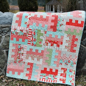 May include: A patchwork quilt with a variety of floral and geometric patterns in shades of red, pink, green, and blue. The quilt is made with a variety of fabrics and is quilted with a simple stitch.
