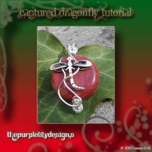 May include: A silver-toned dragonfly pendant with a red stone center. The dragonfly design is detailed, with curved lines and wing accents. The pendant rests on a green leaf, with the text "Captured dragonfly tutorial" and "thepurplelilydesigns" visible.