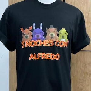 May include: Black t-shirt featuring a colorful graphic of four cartoon animal characters. The text "5 NOCHES CON ALFREDO" is printed in orange and white. The shirt is displayed on a mannequin.