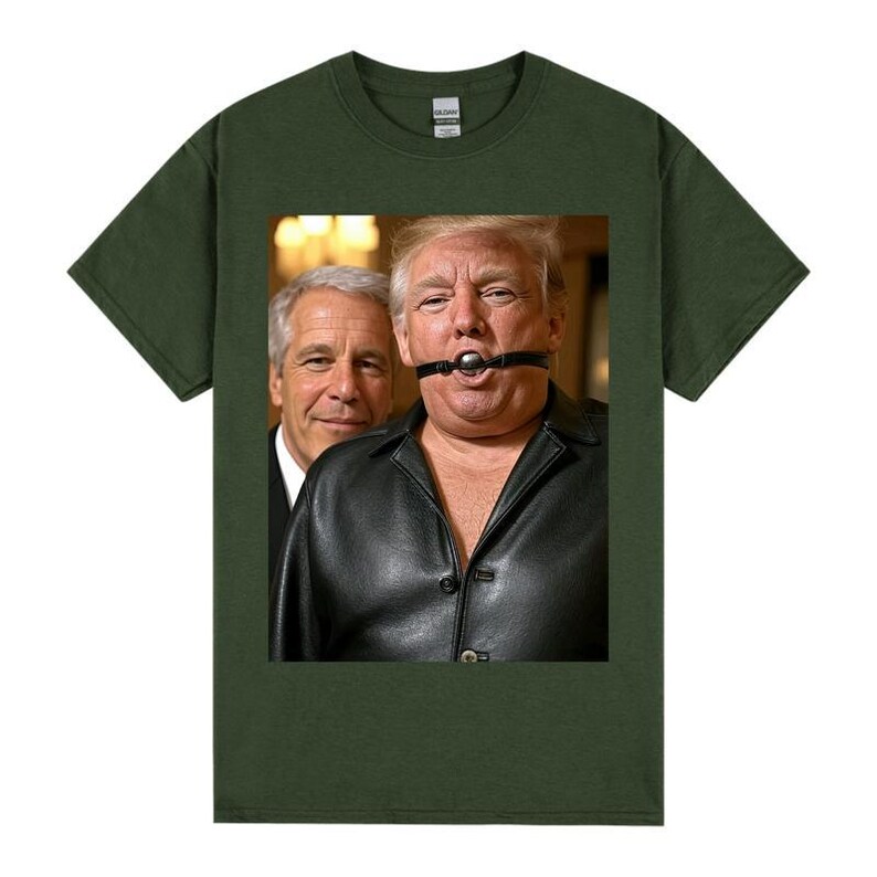 May include: Dark green t-shirt with a graphic of two men. One is wearing a black leather jacket and a ball gag. The other man is wearing a suit. The image is centered on the shirt.