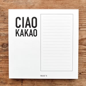 Könnte beinhalten: Ein weißer Notizblock mit dem Text "CIAO KAKAO" in fetten schwarzen Buchstaben. Der Notizblock hat einen linierten Bereich zum Schreiben und einen gepunkteten Bereich. Der Markenname "FRAULENZA IN" ist unten aufgedruckt.