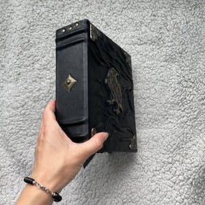 Pu&ograve; includere: Una tazza di ceramica bianca con manico nero e la scritta "But First, Coffee" in nero, in grassetto. La tazza &egrave; appoggiata su una superficie di legno. La tazza &egrave; alta 10 cm.