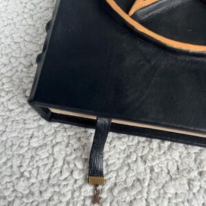 May include: Black leather journal with a gold pentagram design and a gold tassel bookmark.