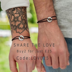 May include: Two people wearing matching black cord bracelets with silver round charms engraved with the words "MY" and "HIM". The text "SHARE THE LOVE Buy 2 for just $25 Code: LOVE25" is displayed below the image.