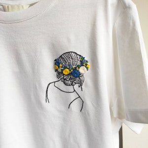 White cotton T-shirt with hand embroidery.  T-shirt with design, print, pattern