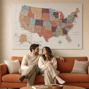 May include: A large rectangular wall map of the United States featuring a muted, multi-colored palette of states, with labels for major cities, states, and bodies of water, including inset maps of Alaska and Hawaii and a compass rose.