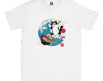 May include: White t-shirt with a black and white cat riding a wave of ramen noodles. The cat is wearing a red collar and the wave is blue with white foam. The text "猫の魂" is in red on a white background.