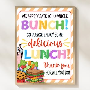 May include: A framed sign with the text "WE APPRECIATE YOU A WHOLE BUNCH! SO PLEASE ENJOY SOME delicious LUNCH! Thank you FOR ALL YOU DO!" Colorful illustrations of a sandwich, salad, muffin, and drink are included.