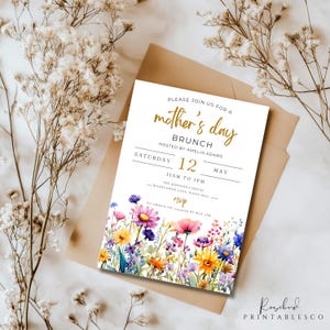 May include: A white invitation card with a floral design and gold lettering. The text reads "Please join us for a mother's day brunch hosted by Amelia Adams Saturday 12 May 11am to 1pm The Johnson's House Wildflower Lane, Daisy Hill, 5322 RSVP to Amelia on or by May 1th"