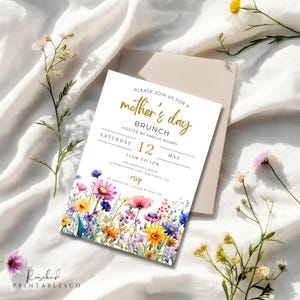 May include: A white invitation card with a floral border and gold lettering. The text reads "Please join us for a mother's day brunch hosted by Amelia Adams Saturday 12 May 11am to 1pm The Johnson's House 43 Wildflower Lane, Daily Mill, 5115 RSVP to Amelia on [phone number] by May 1st"