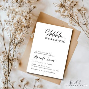 Pu&ograve; includere: Un biglietto d'invito bianco con testo nero che recita "Shhhh... IT'S A SURPRISE!" e i dettagli per una festa di compleanno per i 21 anni. Il biglietto &egrave; su una busta marrone, con fiori secchi sullo sfondo.