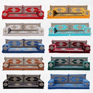 May include: A selection of floor seating sofas in a range of colours: red, yellow, grey, teal, blue, burgundy, brown, green, black, and royal blue. Each sofa has a patterned design on the cushions and base, with matching square ottomans.