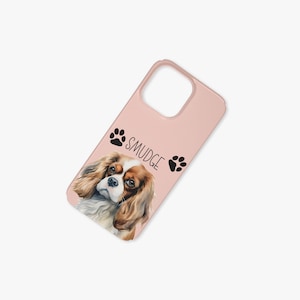 May include: A pink phone case featuring a charming illustration of a Cavalier King Charles Spaniel dog, with the name "Smudge" and paw prints.