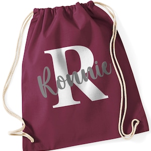 May include: Burgundy drawstring bag with a white letter "R" and the name "Ronnie" in grey text.