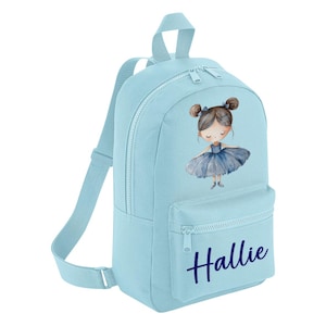 Op de afbeelding: Lichtblauwe canvas rugzak met een voorvak en een ritssluiting. De rugzak heeft een aquarel illustratie van een ballerina meisje in een blauwe tutu en de naam "Hallie" gedrukt in marineblauw.