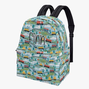 Puede incluir: Una mochila azul con un patrón de tren y el nombre "Finn" impreso en la parte delantera.