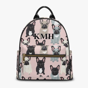 Könnte beinhalten: Rosa Rucksack mit schwarzem Lederbesatz und einem sich wiederholenden Muster aus französischen Bulldoggen. Der Rucksack hat einen goldenen Reißverschluss und die Initialen "KMH" sind in Schwarz auf der Vorderseite aufgedruckt.