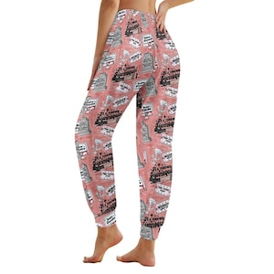Könnte beinhalten: Rosa Jogginghose mit einem sich wiederholenden Muster aus einem Grabstein mit dem Text "It's never a mannequin" und einem Martini-Glas.