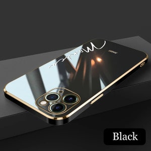 May include: A black phone case with a gold trim and a mirror-like finish. The case has a white inscription that says "more" and the word "Imass" is printed on the back.