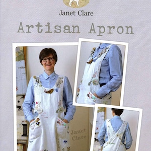 May include: A white apron with a criss-cross back strap and multiple pockets. The apron is decorated with embroidered details, buttons, and fabric scraps. The text "Janet Clare Artisan Apron" is visible at the top of the image.