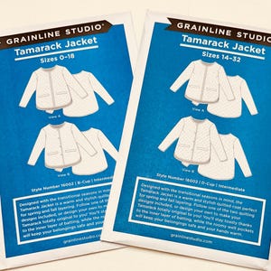 May include: Two blue and white Grainline Studio Tamarack Jacket sewing pattern packets. The packets show jacket illustrations and sizes 0-18 and 14-32. The text on the packets describes the jacket as warm and stylish.