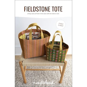 May include: A sewing pattern cover titled FIELDSTONE TOTE, a boxy carry-all tote in two sizes with two views to sew. The image displays two fabric tote bags with yellow handles, one with an orange geometric pattern and one with a green floral print.