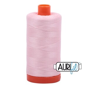 May include: A spool of pink thread with an orange top and bottom. The spool is labeled "Aurifil" in a black rectangle.