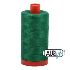 May include: A spool of green thread with a red and orange plastic bobbin. The thread is labeled "Aurifil" in blue.