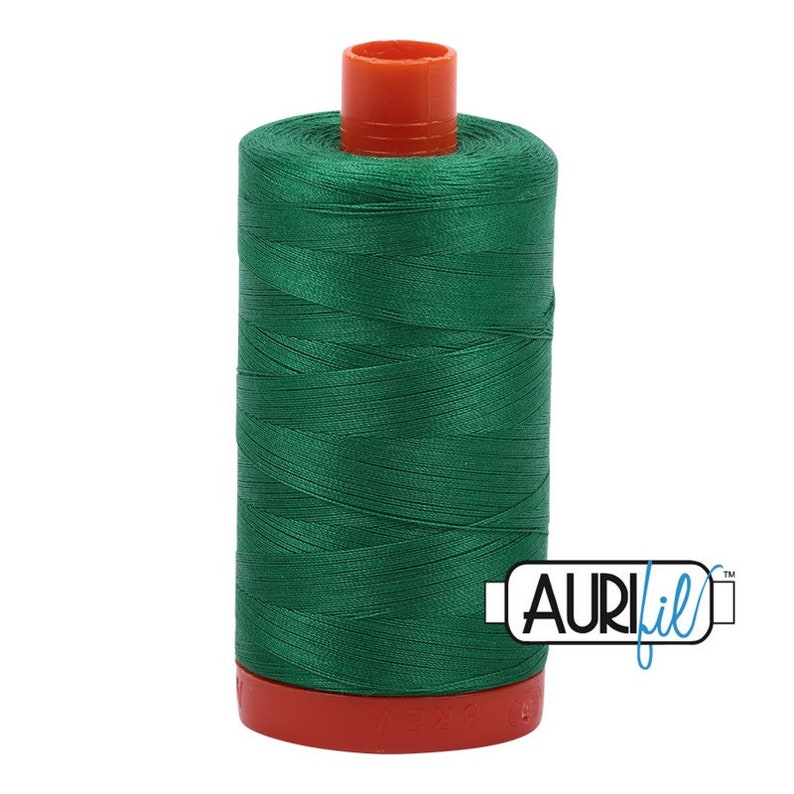 May include: A spool of green thread with a red and orange plastic bobbin. The thread is labeled "Aurifil" in blue.