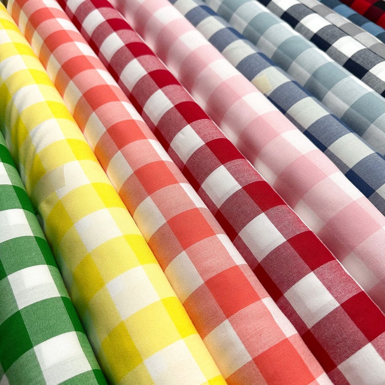 May include: A variety of gingham fabric rolls in different colors, including green, yellow, orange, red, pink, and blue. The fabric has a white background with colored squares.