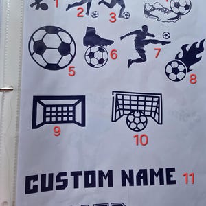 May include: A white sheet with various soccer-themed graphics in navy blue. The graphics include soccer players, soccer balls, a soccer cleat, a soccer goal, and the words "CUSTOM NAME" and "SOCCER".