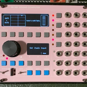 May include: A pink and black electronic music sampler with a screen that reads "Set Chain Input" and "clear". The sampler has a knob, buttons, and jacks.