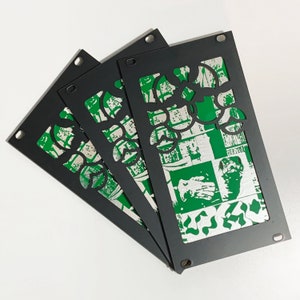 Peut inclure: Trois panneaux muraux en métal noir avec un motif géométrique vert et blanc. Le motif présente un motif répétitif de feuilles et de fleurs.