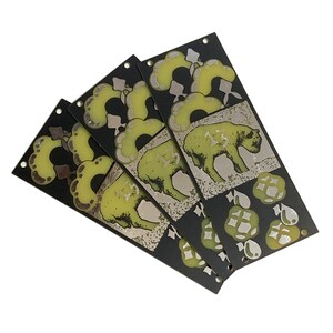 May include: Four black cards with a green and brown design. Each card features a stylised animal and a pattern of leaves and flowers. The cards are arranged in a fan shape.