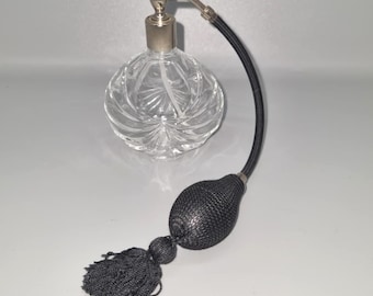 Klasyczny kryształowy flakon z atomizerem do perfum i czarną pompką.