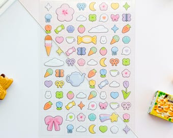 May include: A sheet of clear stickers with pastel colored designs. The stickers feature various cute illustrations, including clouds, stars, hearts, bows, flowers, teacups, and more. The sheet is labeled "clear deco sheet: pastels" and "peko puff".